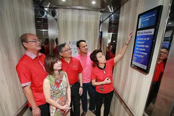 MENINJAU SKRIN: (Dari kiri) Encik Yee Chia Hsing, Dr Amy Khor, Encik Gan Kim Yong, Encik Zaqy Mohamad dan Cik Low Yen Ling melihat salah satu skrin LED yang dipasangkan untuk memperbaiki perhubungan bersama penduduk di kawasan itu. - Foto CMG