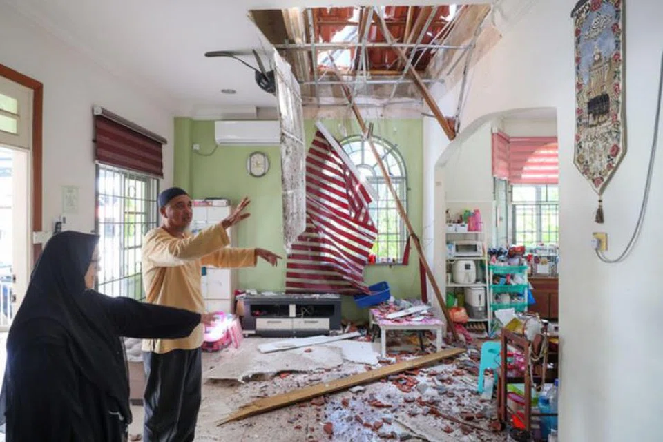 Penduduk Kampung Gong Pauh, Chukai, Terengganu, Encik Abdullah Zawawi Che Yaakob, 63 tahun, bersama isterinya, Cik Wan Kharzimi Wan Abd Manan, 57 tahun, menunjukkan bahagian di kediaman mereka yang rosak akibat ribut dan hujan batu pada petang 22 Oktober.