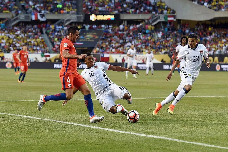 Pemain Colombia, Frank Fabra (nombor 18), mencuri bola daripada pemain Chile, Mauricio Isla (4), dalam perlawanan separuh pertama Copa America Centenario di Soldier Field di Chicago. 