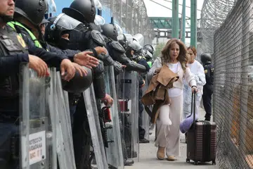 Seorang penumpang berjalan melepasi anggota polis antirusuhan ketika tiba di Terminal 1 Lapangan Terbang Antarabangsa Benito Juarez, ketika pihak berkuasa bersiap sedia menghadapi bantahan oleh kumpulan guru pembangkang Kesatuan Nasional Pekerja Pendidikan Mexico (CNTE), menjelang Piala Dunia FIFA 2026 di Mexico City, Mexico pada 10 Jun 2026.