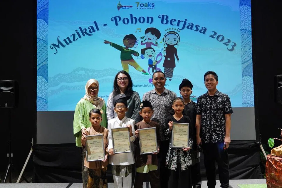 DUTA CILIK: Rakan Bahasa Cilik 2023 (dari kiri, barisan depan) Nufah Imani Amat Halim, Putra Al Hassan Edyputra, Zubir Ahmad Muhammad Darwis dan Zara Rizqah Mohammad Rashid, bersama antara lain Pengerusi Jawatankuasa Bulan Bahasa 2023, Encik Zhulkarnain Abdul Rahim (tengah, barisan belakang) dan Presiden PPIS, Cik Hazlina Abdul Halim (di kanannya).