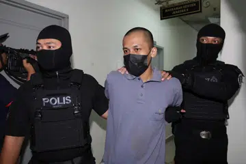 Radin Romyullah Radin Imran, 34 tahun, (tengah) dituduh pada 16 Oktober menggalakkan perbuatan pengganas dengan menanam ideologi kumpulan pengganas IS. Empat lagi ahli keluarganya turut didakwa di mahkamah atas tuduhan sama. 