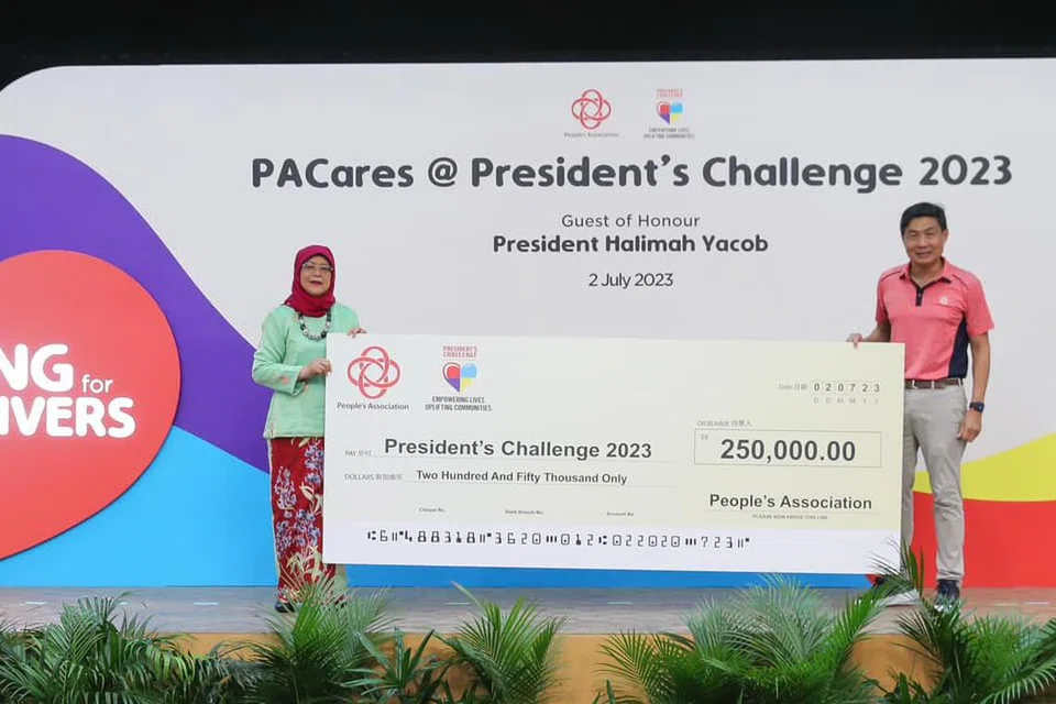 SOKONGAN BAGI CABARAN PRESIDEN: Presiden Halimah Yacob menerima cek sumbangan Persatuan Rakyat (PA) daripada Ketua Pengarah Eksekutif Encik Jimmy Toh, di Kelab Masyarakat Hong Kah North pada 2 Julai 2023.