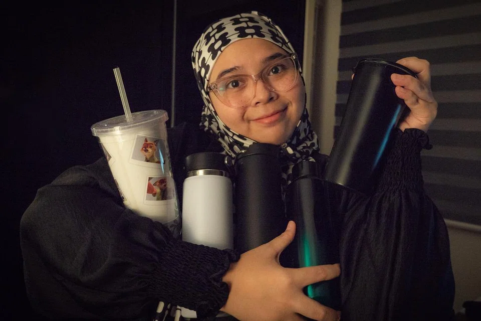 Cik Nurhaziqah Ismail bersama lima termosnya. Beliau mempunyai termos berbeza untuk digunakan di pejabat, rumah dan dibawa keluar di samping turut membezakan termos bagi air berperisa dan air tawar. 