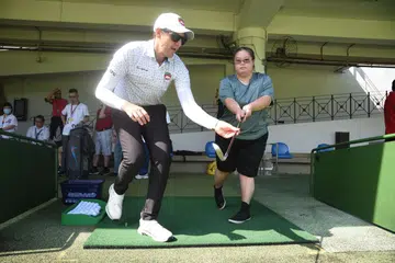 PENGENALAN PADA GOLF: Seorang peserta diperkenalkan kepada golf, oleh jurulatih nasional, Murray Smit (kiri) menerusi program pendekatan bersama SDSC sempena Minggu Golf SGA.