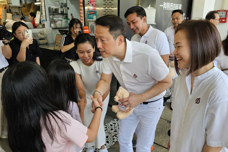 Pasukan Parti Tindakan Rakyat (PAP), yang terdiri daripada (dari kanan) Cik Theodora Lai, Profesor Madya Dr Elmie Nekmat, Dr Lam Pin Min dan Cik Bernadette Giam mengedarkan patung beruang PAP GRC Sengkang kepada kanak-kanak yang sedang menjamu selera di Blok 170 Sengkang East Drive pada 30 Mac.