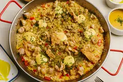 Paella con Pollo dimasak dengan ayam dan lada benggala, yang dihiasi dengan kulit ayam yang mempunyai perisa telur masin untuk kerangupan tekstur dalam setiap gigitan.