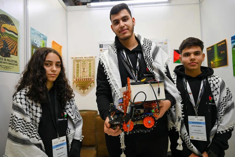 Peserta Palestin - (dari kiri) Razan Shawar, Mustafa Assi dan Jehad Abudayyeh - yang bertanding dalam kategori Inovator Akan Datang (Future Innovators) bersama projek mereka.