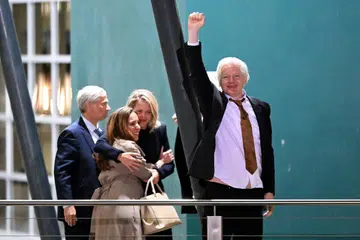 Pengasas WikiLeaks, Julian Assange, mengangkat tangan dan genggam jejari sebagai memberi isyarat kebebasannya sebaik pesawat peribadi beliau mendarat di Canberra, Australia, pada 26 Jun.