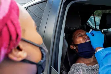 ADUH MAK!: Seorang wanita menjalani ujian Covid-19 di tapak pandu lalu yang dikendalikan seorang teknisyen makmal Mullah Laboratories di tempat meletak kereta Flower Hall, di Universiti Wits, Braamfontein, Johannesburg, semasa kempen ujian Covid-19 pada 5 Januari lalu. - Foto AFP