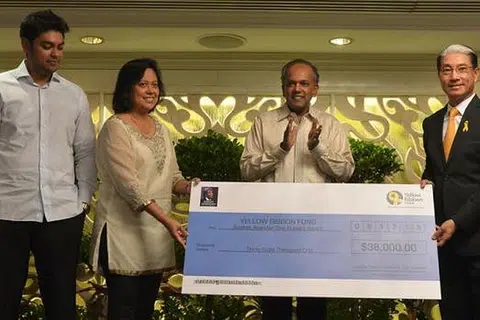 TERUS MENYUMBANG: Anak mendiang Subhas Anandan (kiri), Encik Sujesh Anandan bersama isteri, Cik Vimala Anandan, bergambar bersama Encik Shanmugam dan naib pengerusi Dana Riben Kuning, Encik Lucas Chow, di majlis pelancaran buku It's Easy To Cry. - Foto THE STRAITS TIMES