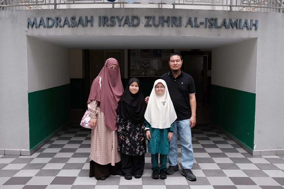 SOKONGAN KELUARGA: Aeisyah Nusaybah Mohamad Rahsid (dua dari kanan) ditemani ibunya, Cik Faezah Zaiton; adiknya, Faathimah Rufaydah Mohamad Rahsid (tudung hitam), dan bapanya, Encik Mohamad Rahsid Mustaffa, ketika menerima keputusan Peperiksaan Tamat Sekolah Rendahnya di Madrasah Irsyad Zuhri Al-Islamiah pada Rabu.