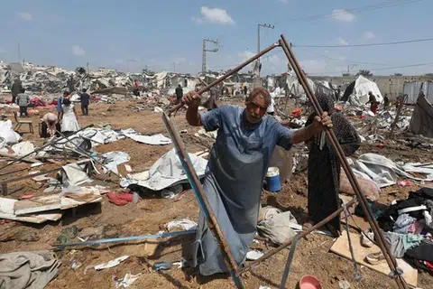 Seorang lelaki Palestin yang kehilangan tempat tinggal sedang mengumpulkan barangannya pada 21 Ogos selepas serangan Israel ke atas sebuah kem pelarian di Deir el-Balah, di tengah Jaluran Gaza. 