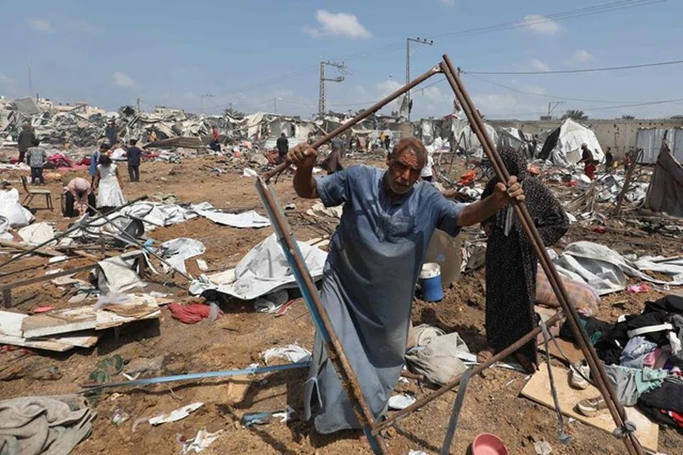 Seorang lelaki Palestin yang kehilangan tempat tinggal sedang mengumpulkan barangannya pada 21 Ogos selepas serangan Israel ke atas sebuah kem pelarian di Deir el-Balah, di tengah Jaluran Gaza. 