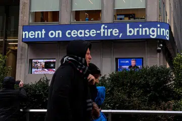 Orang ramai melintasi papan pemberitahuan Fox News yang mengumumkan perjanjian gencatan senjata antara Israel dan Hamas di ibu pejabat News Corp dan WSJ di New York City, Amerika Syarikat, pada 15 Januari.
      