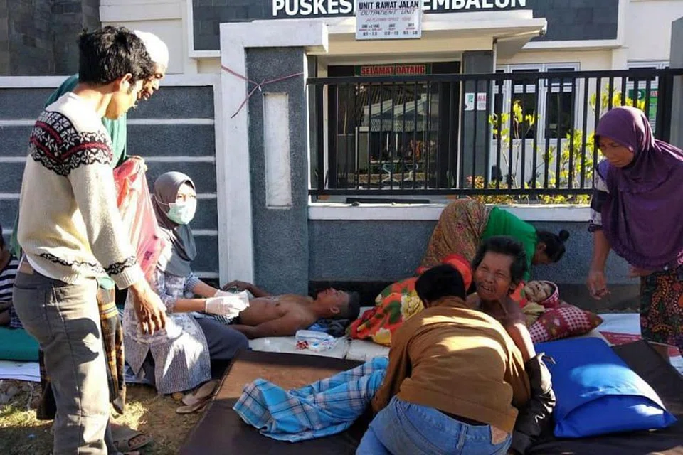 BERI BANTUAN: Paramedik membantu individu yang cedera di luar hospital selepas satu gempa bumi yang melanda Lombok pada 29 Julai 2018.