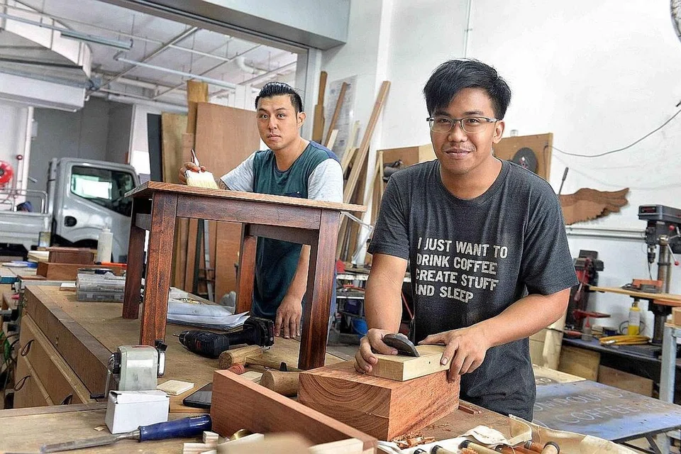 DESAIN DAN TUKANG: Encik Rafie Chua (depan) dan teman perniagaan, Encik Jonathan Tan (belakang), puas hati dapat membuat perabot yang memenuhi permintaan pelanggan menerusi syarikat pertukangan kayu mereka, Plane and Bevel. - Foto M.O. SALLEH
