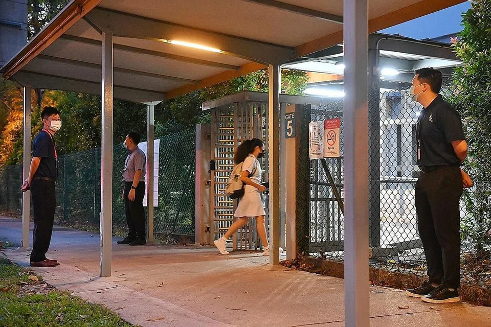 KEMBALI KE SEKOLAH: Beberapa kakitangan sekolah dan pegawai keselamatan dilihat berdiri di luar kampus pagi semalam sedang pelajar kembali ke sekolah. - Foto BH