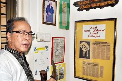 PASTIKAN WARISAN DAN SEJARAH ORANG BANJAR TERPELIHARA: Encik Abdul Latiff memegang beladau yang diwarisi turun-temurun di sudut sejarah orang Banjar di flatnya di Pasir Ris. - Foto JOHARI RAHMAT