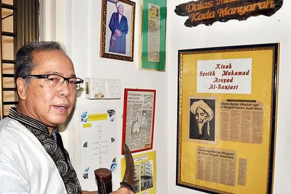 PASTIKAN WARISAN DAN SEJARAH ORANG BANJAR TERPELIHARA: Encik Abdul Latiff memegang beladau yang diwarisi turun-temurun di sudut sejarah orang Banjar di flatnya di Pasir Ris. - Foto JOHARI RAHMAT