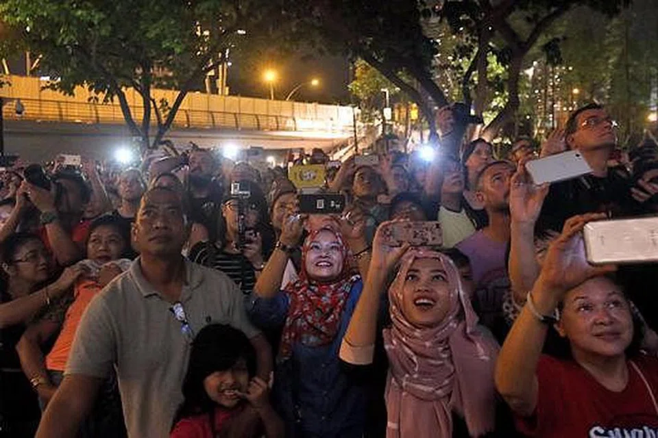 DI SINGAPURA - RAKAM KENANGAN: Orang ramai bersengkang mata agar tidak terlepas menyambut kemeriahan sambutan Tahun Baru 2016 di Marina Bay. - Foto ZAOBAO