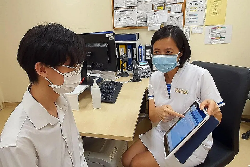 MANFAATKAN TEKNOLOGI: Seorang jururawat poliklinik menggunakan sistem saringan dan klasifikasi bijak di iPad untuk membantu menilai sama ada seorang pesakit yang mengalami sakit dada menghidap penyakit jantung koronari. - Foto SINGHEALTH POLYCLINICS