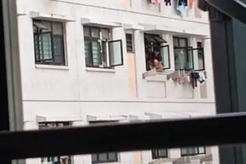 Wanita ini kelihatan menyangkung sekitar 15 minit di belebas tingkap sebuah unit tingkat enam. di Yishun. 