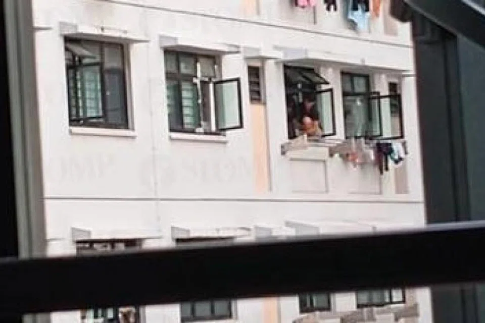 Wanita ini kelihatan menyangkung sekitar 15 minit di belebas tingkap sebuah unit tingkat enam. di Yishun. 