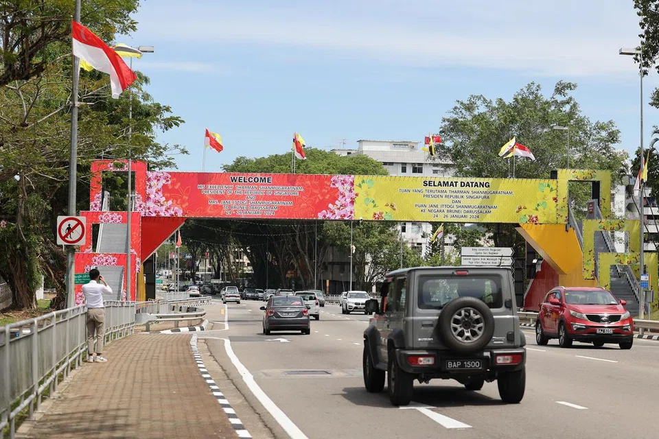 Bendera Singapura dan panji yang memaparkan mesej sambutan mesra ketibaan Presiden Tharman Shanmugaratnam, dan isterinya, Cik Jane Ittogi Shanmugaratnam, ke Brunei berkibar di jalan raya Bandar Seri Begawan.