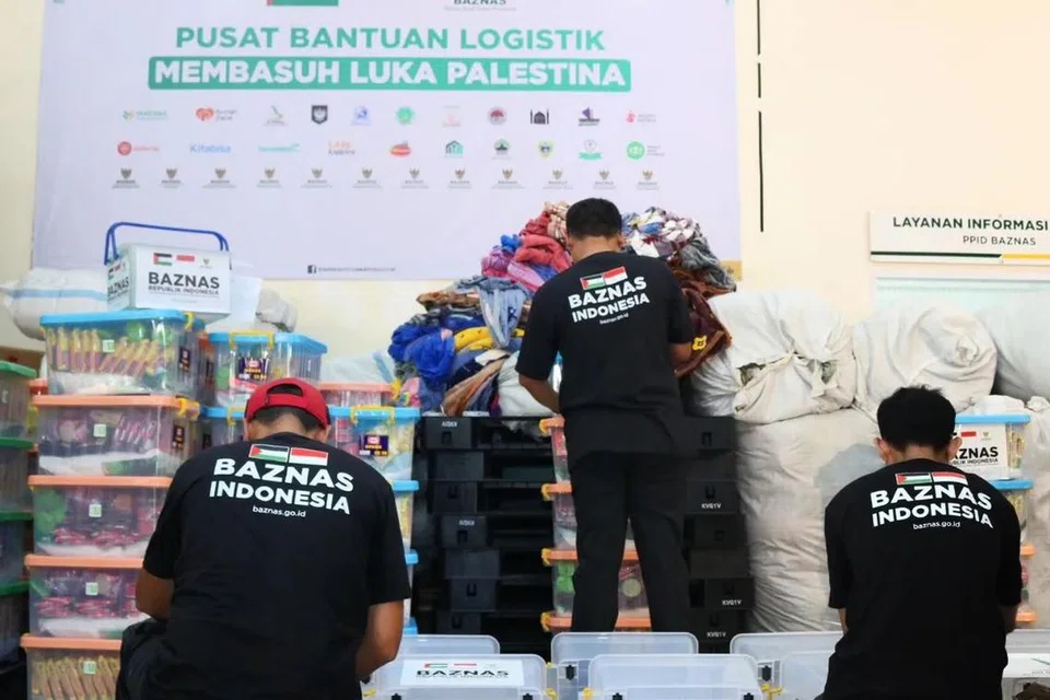 HULUR BANTUAN: Relawan Badan Amil Zakat Nasional (Baznas) bergotong-royong menyiapkan bantuan paket logistik untuk Palestin yang dijangka diterbangkan ke Mesir pada Sabtu.
