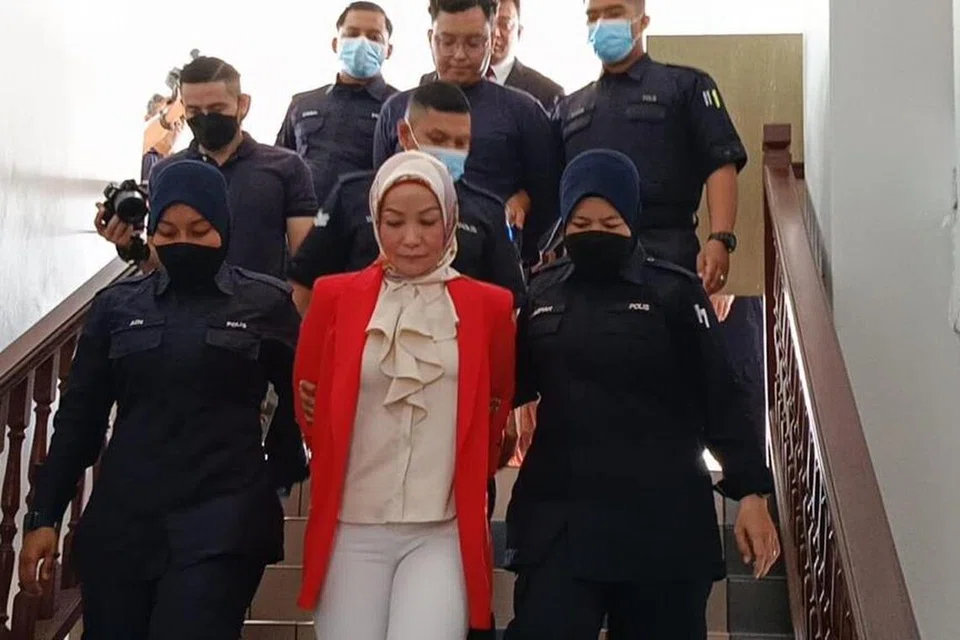 HADAPI TUDUHAN: ‘Mak cik Kemboja’ atau nama sebenarnya, Mariyah Yaakob, 47 tahun (baju jingga) yang tular dengan kontroversi melabel Melayu malas, dihadapkan ke Mahkamah Sesyen Ayer Keroh, Melaka, pada 7 Disember.