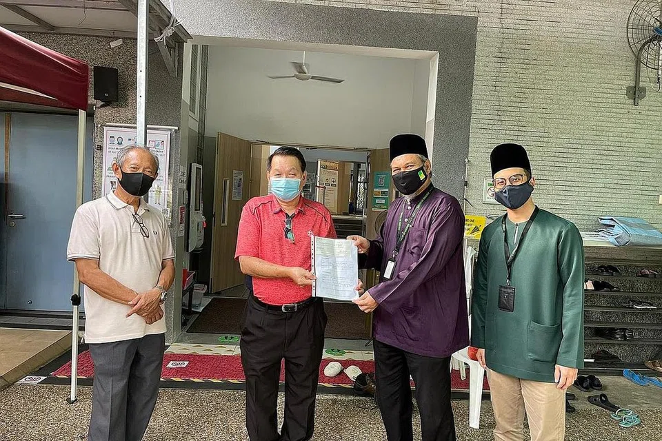 TERIMA BANTUAN: Pengurus Kanan Kelab Masyarakat (CC) Bukit Batok, Encik Lim menyerahkan cek bernilai $2,000 daripada rakannya sebagai tanda sokongan terhadap Projek Peningkatan Masjid Ar-Raudhah. - Foto MASJID AR-RAUDHAH
