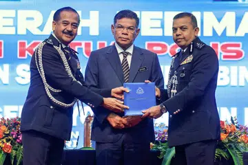 PELANTIKAN BARU: Menteri Dalam Negeri, Datuk Seri Saifuddin Nasution Ismail (tengah) menyaksikan penyerahan dokumen tugas Timbalan Ketua Polis Negara (IGP) antara Tan Sri Razarudin Husain (kiri) kepada Datuk Seri Ayob Khan Mydin Pitchay (kanan) pada majlis serah terima tugas di Dewan Tan Sri Abdul Rahman Hashim, Pusat Latihan Polis Kuala Lumpur (Pulapol) pada Khamis. Tan Sri Razarudin dilantik sebagai IGP baharu berkuat kuasa Jumaat, menggantikan Tan Sri Acryl Sani Abdullah Sani, yang tamat perkhidmatannya pada Khamis.