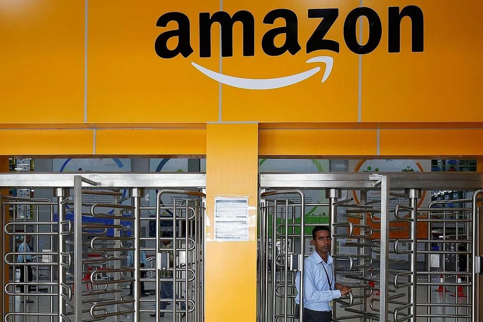 TEMBUSI PASARAN: Seorang pekerja Amazon berjalan melalui pintu lawang Pusat Penyampaian Amazon, yang memenuhi tempahan pelanggan, di pinggir Bangalore, India. - Foto fail REUTERS 
