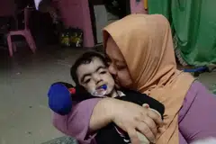 PENUH KASING SAYANG: Cik Zainab Salim bersama anaknya Mohammad Hazim Muhaimin Mohamad, yang menghidap sindrom Cornelia de Lange dan dijangka tidak hidup lama pada mulanya.