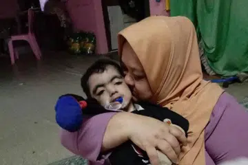 PENUH KASING SAYANG: Cik Zainab Salim bersama anaknya Mohammad Hazim Muhaimin Mohamad, yang menghidap sindrom Cornelia de Lange dan dijangka tidak hidup lama pada mulanya.