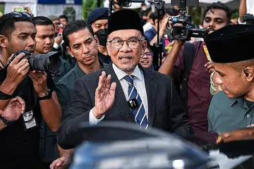 BINCANG BENTUK KERAJAAN BARU: Pemimpin PH, Datuk Seri Anwar (atas), dilihat di luar Istana Negara selepas mengadakan pertemuan dengan Agong bersama-sama pemimpin PN, Tan Sri Muhyiddin (gambar kanan) semalam. - Foto AFP