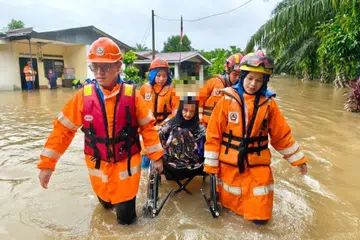 Anggota Angkatan Pertahanan Awam Malaysia (APM) memindahkan mangsa banjir di Yan, Kedah, pada 25 Oktober.