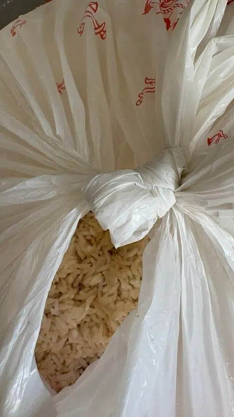 Beras mentah yang diikat dalam plastik terletak di luar rumah unit itu.