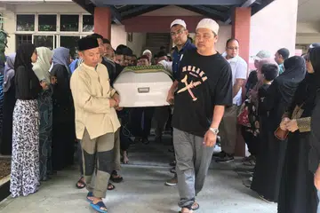 REDA PEMERGIANNYA: Kesyahduan dirasakan tatkala keranda jenazah Allahyarham Rosli diangkat sanak saudara serta sahabat handai untuk dimasukkan ke dalam van bagi dibawa ke Pusara Aman. - Foto FARID HAMZAH