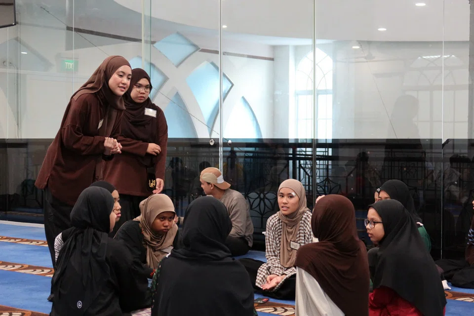 Cik Mira Sorfina Noor Asrin (kiri), aktivis kumpulan belia Wildan dari Masjid Al-Istighfar, memberi taklimat kepada belia yang mengambil bahagian dalam kem anjuran masjid tersebut pada 20 Jun.