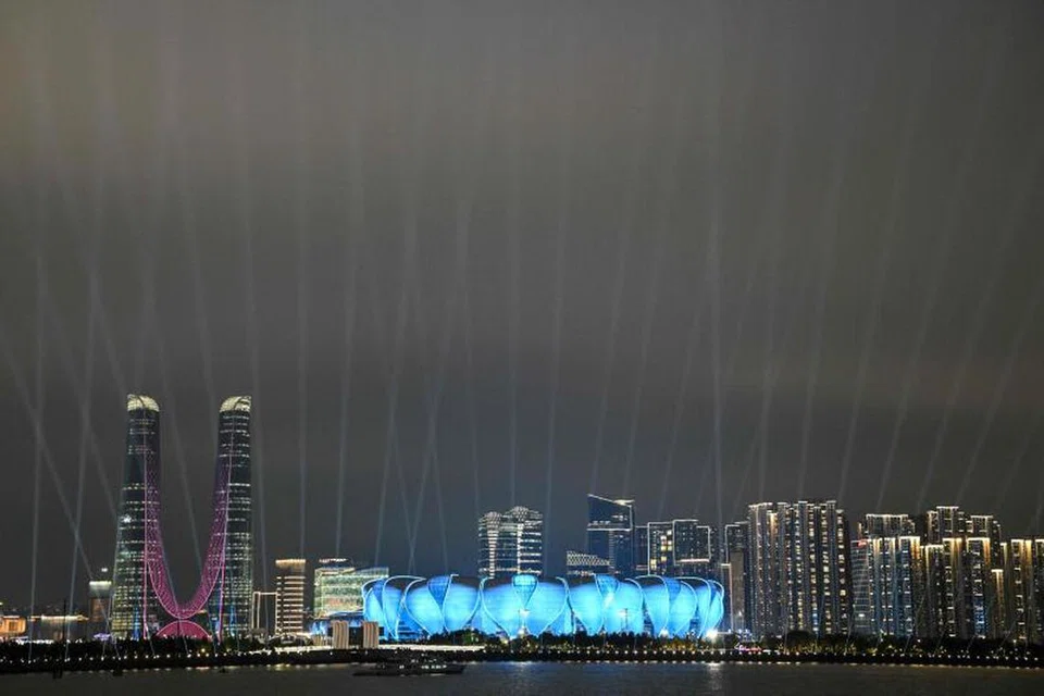 JADI TUMPUAN: Stadium Pusat Olimpik Hangzhou, yang juga dinamakan “Teratai Besar”, dan bangunan tinggi di sekitarnya terang dinyalakan oleh lampu semasa majlis pembukaan Sukan Asia Hangzhou pada Sabtu. 