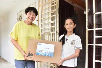 SEMANGAT MEMPERBAIKI KEHIDUPAN ORANG LAIN: Presiden SCS, Dr Chong Yoke Sin, menyampaikan derma komputer riba kepada Nurul Amira Natasya di rumahnya. - Foto PERSATUAN KOMPUTER SINGAPURA (SCS)