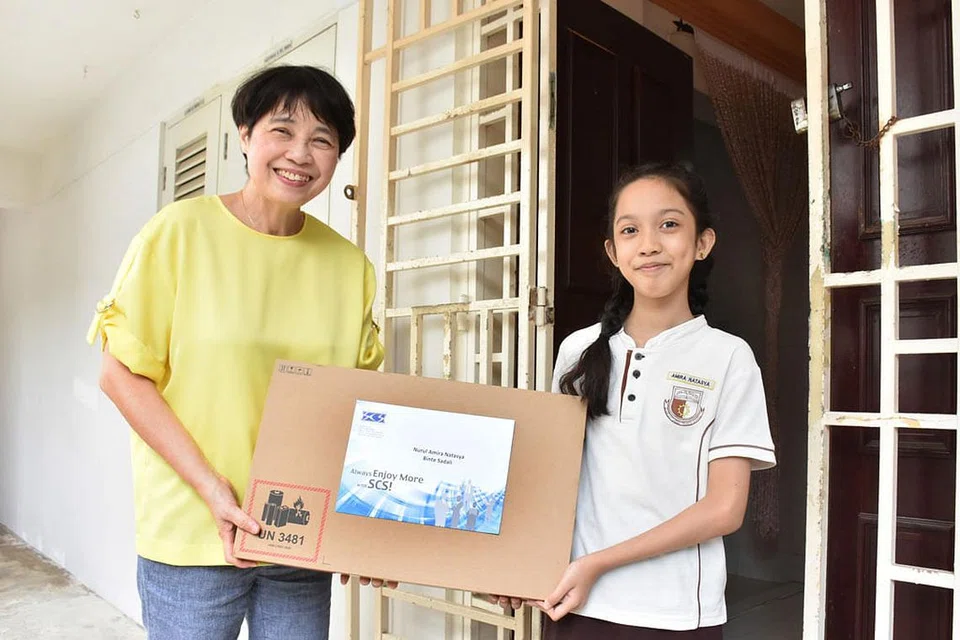 SEMANGAT MEMPERBAIKI KEHIDUPAN ORANG LAIN: Presiden SCS, Dr Chong Yoke Sin, menyampaikan derma komputer riba kepada Nurul Amira Natasya di rumahnya. - Foto PERSATUAN KOMPUTER SINGAPURA (SCS)