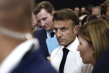 AKAN USAHA: Encik Emmanuel Macron (baju putih) yang ditemui di luar pameran VivaTech di Paris berkata beliau akan berusaha agar Mbappe kekal di PSG.