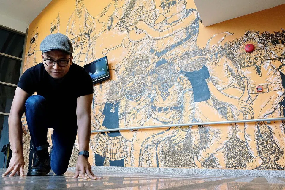 BIJAK MEMIKIRKAN KONSEP KARYA SENI: Encik Farizwan Fajari yang merupakan mentor program bakat seni muda Majlis Seni Kebangsaan (NAC), Noise Singapore, bersama tembok mural ilustrasinya yang bertemakan muzik dan dijadikan hiasan luar di Studio Resital Esplanade. - Foto KHALID BABA