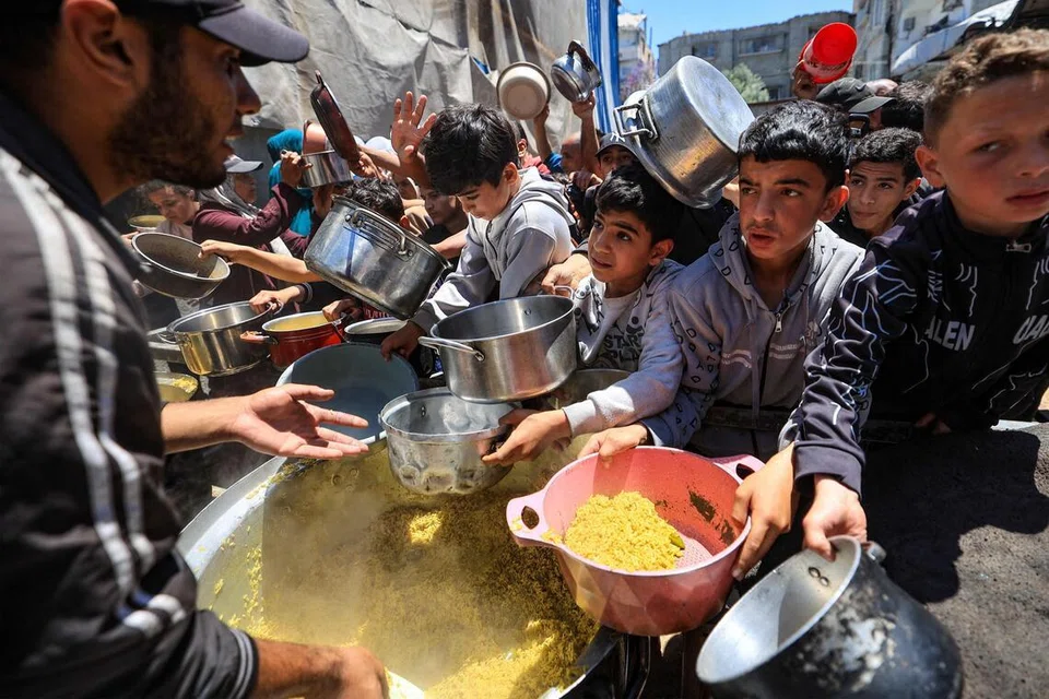 Penduduk Palestin berebut untuk mendapatkan makanan panas di kem pelarian Nuseirat di tengah Gaza pada 7 Mei 2026, ketika Parlimen Israel meluluskan undang-undang baharu yang membuka laluan kepada perbicaraan ketenteraan terhadap ratusan rakyat Palestin yang ditahan kerana disyaki terbabit dalam serangan Hamas ke atas Israel pada 7 Oktober 2023. Walaupun gencatan senjata diumumkan pada Oktober lalu, Gaza terus dibelenggu keganasan harian dengan serangan Israel masih berterusan.