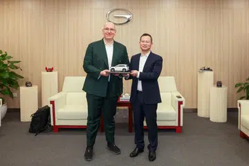 Ketua Pegawai Produk Grab, Encik Philipp Kandal (kiri), dihadiahkan sebuah model kereta oleh Presiden syarikat automotif China, GAC Group, Encik Xia Xianqing, pada 7 Januari.