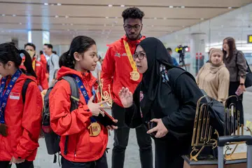 KEMBALI DENGAN KEMENANGAN: Atlet Terbaik pasukan silat Singapura, Aura Aydria Putri Soffian dan Sheik Ferdous Sheik Alau’ddin bersama Pengarah Pemasaran dan Promosi Persekutuan Silat Singapura (Persisi), Cik Nur Asiah Arshad di Terminal 1 Lapangan Terbang Changi. 
