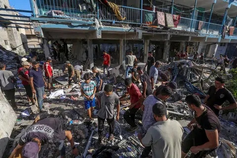 Para penduduk Palestin mencari mereka yang mungkin tertimbus di bawah runtuhan bangunan ekoran serangan udara Israel ke atas sebuah sekolah yang dijadikan tempat perlindungan pelarian Palestin di Nuseirat di tengah Gaza pada 11 September.